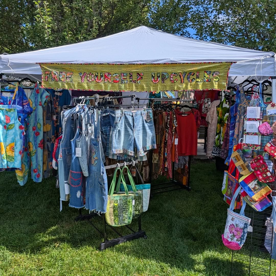 Free Yourself Upcycles market booth with the hand-embroidered banner